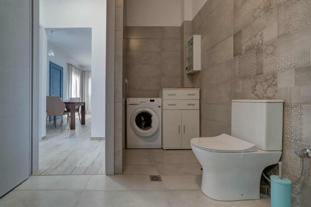 The bathroom with the washing machine of Gina' house
