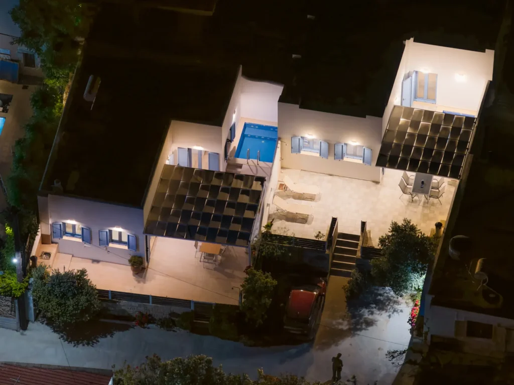 The two houses lit up at night, seen from above